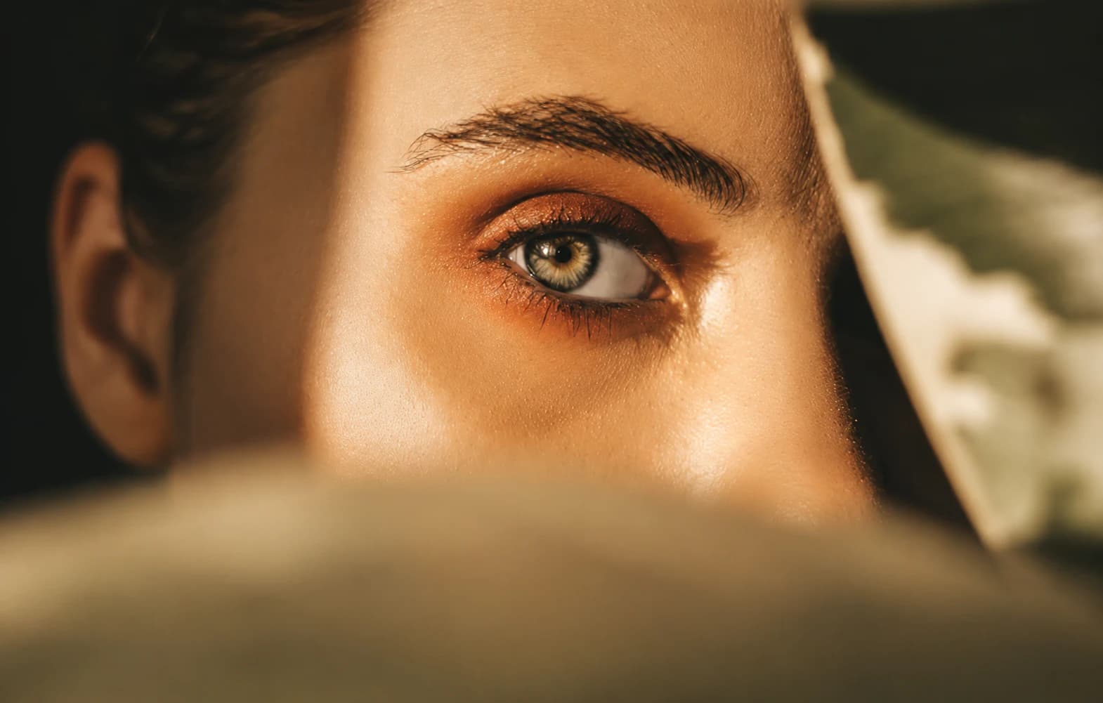 Close-up of a woman’s eye in warm, low light